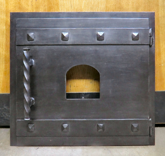Craftsman style hand forged wrought iron pizza oven door with rivets