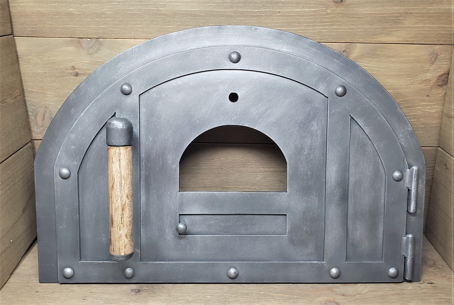 sleek simple rustic pizza oven door hinged on frame with pewter patina